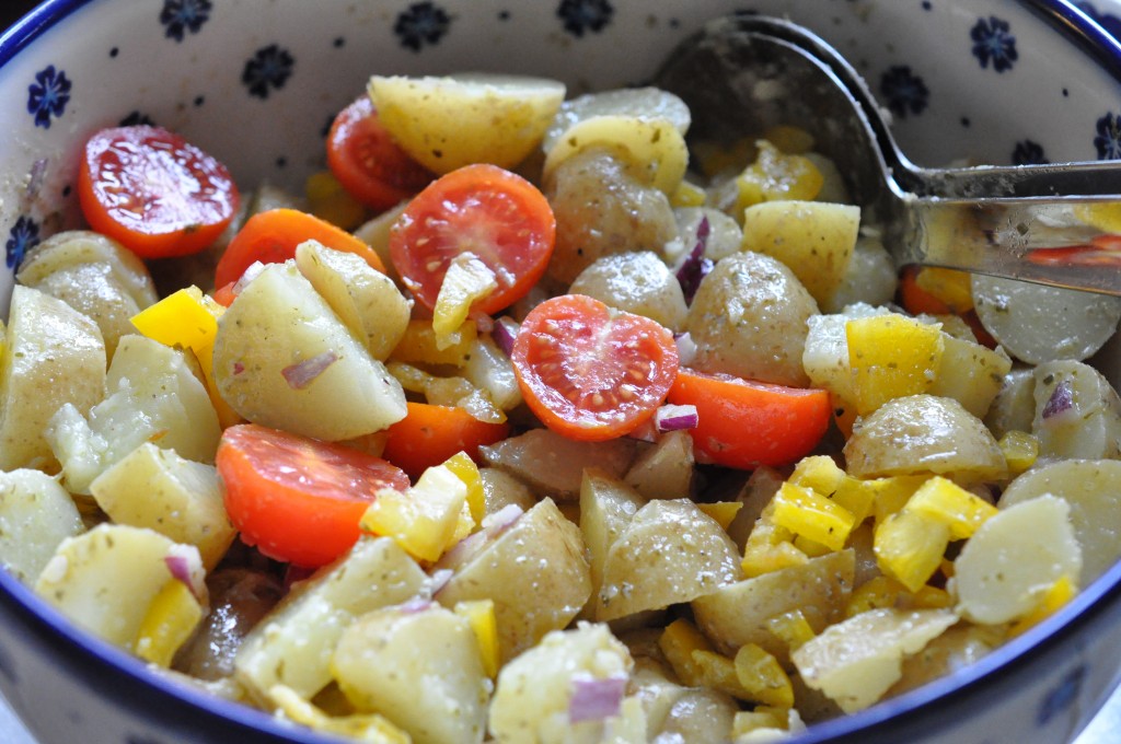 Kartoffelsalat med pesto, rødløg & peberfrugt 1 kg nye kartofler (gerne små hurtige, der er købt vaskede) 1 finthakket peberfrugt (rød eller gul) 1 finthakket rødløg 250-300 gram cherrytomater Pesto marinade: 3 spsk. god olivenolie (f.eks. extra jomfru olivenkerne) 1 spsk pesto (rød eller grøn kan bruges) 1 spsk. hvidvinseddike eller citronsaft 1 tsk.dijonsennep Salt/peber Fremgangsmåde: Snit de kolde kogte kartofler Snit løg og peberfrugt.  Bland kartofler og grønt Nu skal marinaden laves. Jeg havde en rest pesto i bunden af et glas. Jeg puttede olien heri og rystede glasset godt, så jeg kunne få al pestoen med. Jeg brugte min extra gode jomfruolienolie. Til en salat du skal spise "au naturel" skal det helst være en god smagfuld olie (jeg bruger en billigere variant, til fødevarer jeg skal opvarme f.eks.) Jeg tilsatte 1 tsk sennep til pestodressingen og krydrede med salt og peber og hvidvinseddike, for at tilføre lidt syrlighed. Den blev HAMRENDE god den dressing! Tror jeg skal prøve den næste gang jeg skal ovnstege pestokartofler, sennepsmarinaden må også kunne bruges til varme kartoffelretter? Tja tjo kønt ser det ikke ud. Vi skal vist ikke tale om hvad det ligner her men LÆKKERT smager det! Har du en rest pesto, så smid den endelig ikke ud. Brug den i din dressing/marinade/gryderet (find selv på flere forslag..;-) Kartoffelsalaten vendes rundt med marinade og det hele. Vend forsigt, så kartoflerne ikke moses.  Tilsæt tomater til sidst og lad gerne kartoffelsalaten trække lidt. Gerne 1 time inden servering (så lang tid kunne vi dog ikke vente i dag ;-)