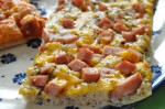 Pizza med skinke, hvidløgsolie, cocktailpølser og peberfrugtpesto