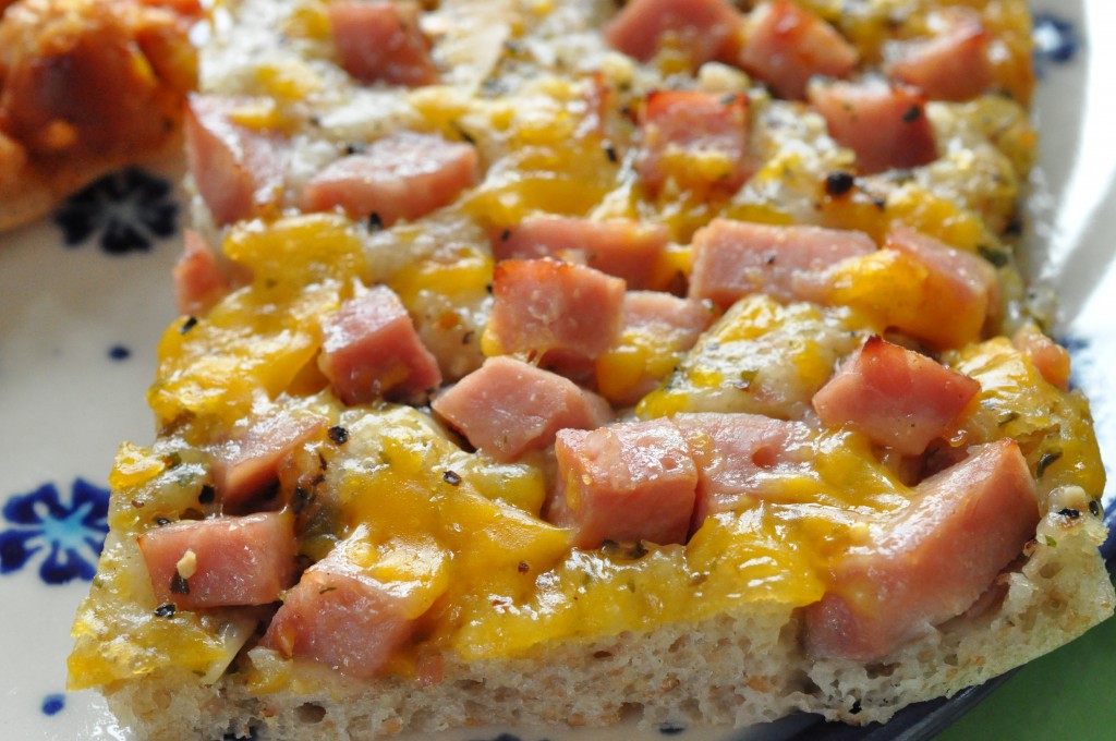 Pizza med skinke, hvidløgsolie, cocktailpølser og peberfrugtpesto