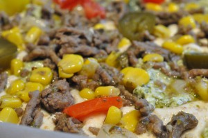 Oksekødspizza med løg, hvidløg, jalapenos, peberfrugt, flødeost og pesto