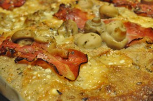 Grov pizza af koldthævet dej med parmesanost og parmaskinke