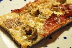 Grov pizza af koldthævet dej med parmesanost og parmaskinke