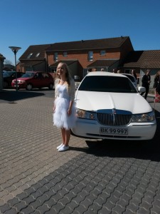 Konfirmation, grin, sol, limousine og en smuk glad pige