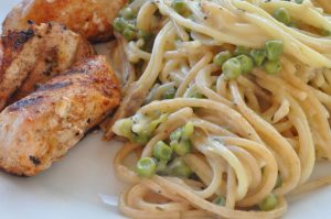 Pasta i flødesovs med ærter og grillet kylling