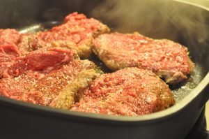 Steaks i flødesauce med tomat, løg og hvidløg