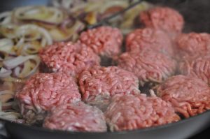 Hakkebøf med bløde, glaserede løg og pommes frites med sesam