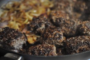 Hakkebøf med bløde, glaserede løg og pommes frites med sesam