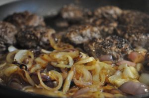 Hakkebøf med bløde, glaserede løg og pommes frites med sesam