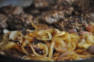 Hakkebøf med bløde, glaserede løg og pommes frites med sesam