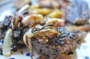 Hakkebøf med bløde, glaserede løg og pommes frites med sesam