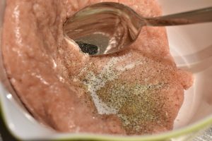Hakket kylling røres med salt og peber