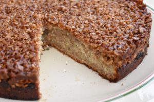 Saftig banankage med sprød topping - hel kage, hvor der er skåret et stykke