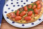 Æggewrap med ristet rugbrød og tomater - nem foldet omelet. Pyntes med purløg og tomater