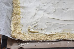 Butterdejen rulles ud og smøres med flødeost. Kanten laves.