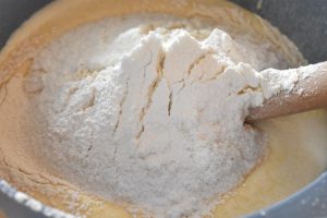 Hvedemel og bagepulver sigtes og vendes i